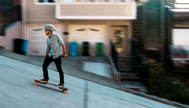 man riding on electric skateboard uphill