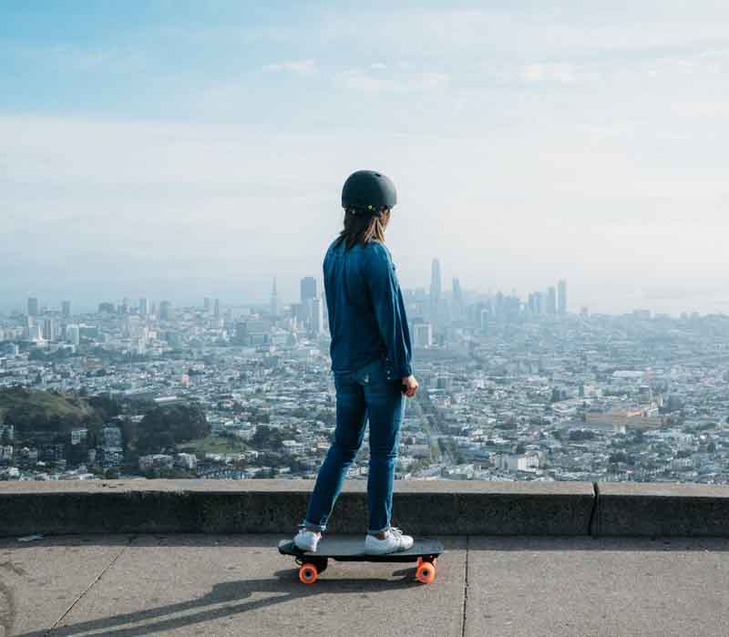 girl enjoying beautiful city view with electric skateboard